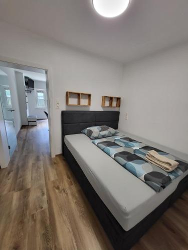 a large bed in a room with wooden floors at Apartment Karin in Langenwang