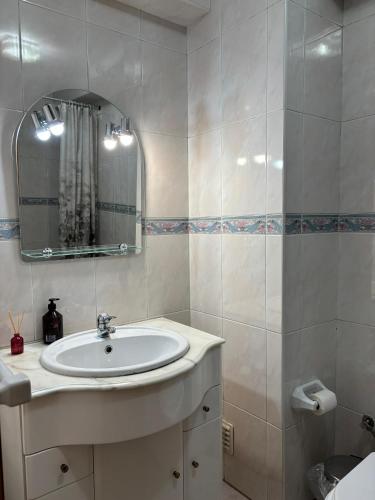a white bathroom with a sink and a mirror at Brisa do Mar in Vagos