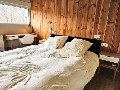 a bedroom with a large bed with wooden walls at Modern Spacious Forest Home in Aywaille
