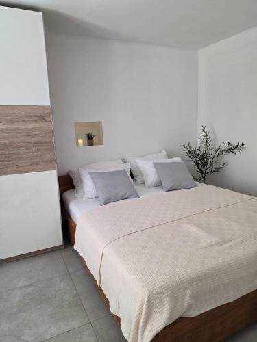 a bedroom with a large bed with white sheets and pillows at Apartments Jelinek in Brela