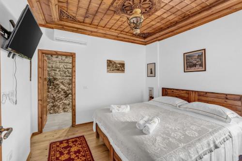 a bedroom with a bed and a flat screen tv at Guest House J.Prifti in Berat