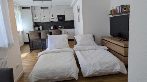 two beds in a living room with a kitchen at Rudolph Apartments Kleve in Kleve