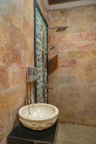 a bathroom with a large stone sink on a counter at D'nala Villa - 4 bedroom villa in Lebih