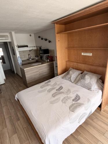 a large bed in a room with a kitchen at Studio cosy climatisé vue sur port in Cap d'Agde