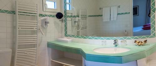 a bathroom with a sink and a mirror at hôtel Sube in Saint-Tropez