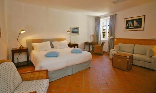 a bedroom with a large bed and a living room at hôtel Sube in Saint-Tropez