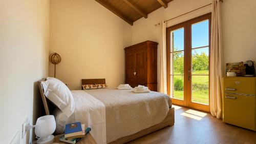 a bedroom with a bed and a large window at B&B Il Nocciolino in La Fabbrica