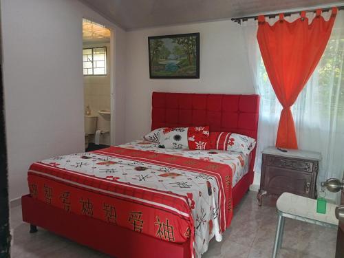a red bed in a bedroom with a red headboard at Alojamiento Sol y Luna in La Mesa
