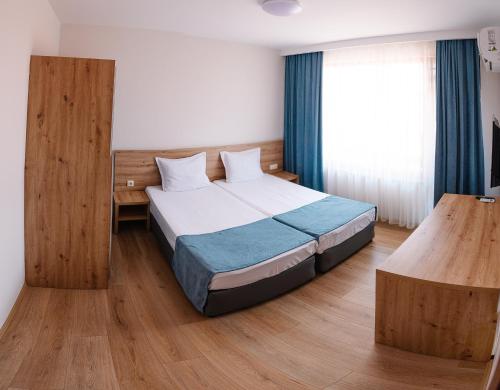 a hotel room with a bed and a window at Stamatovi Family Hotel in Pomorie