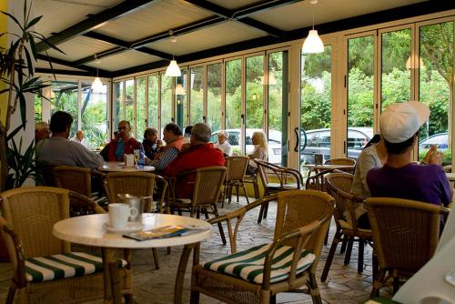 un gruppo di persone sedute ai tavoli di un ristorante di Hotel Rado a Lido di Jesolo