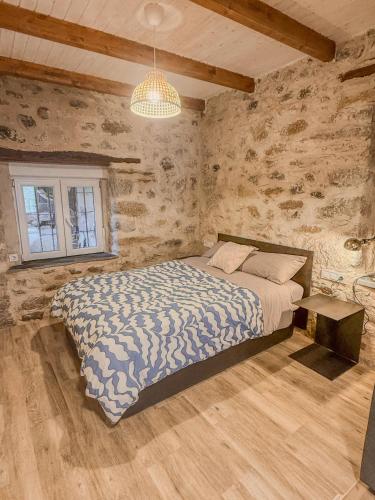 a bedroom with a bed in a room with stone walls at Apartamento Las Medulas in Covas