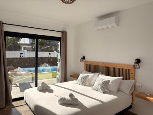a bedroom with a large bed with towels on it at Casa El Cachorro in La Oliva