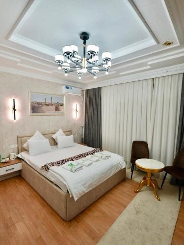 a bedroom with a large bed and a chandelier at Milliy Hotel - Namangan city in Namangan