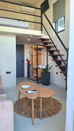 a living room with a table and a staircase at Dris Loft in Nikiana