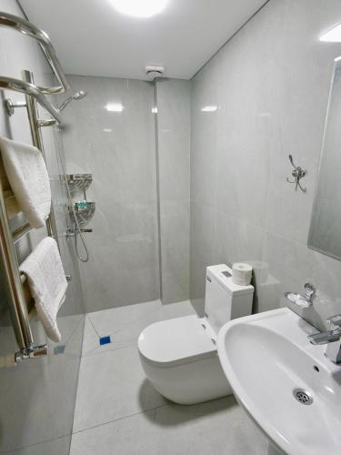 a bathroom with a toilet and a sink and a shower at Milliy Hotel - Namangan city in Namangan