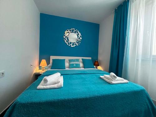 a bedroom with a blue bed with towels on it at Apartment Decumana in Krk