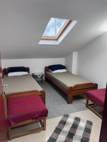 a small room with two beds and a window at Beara in Lepetani