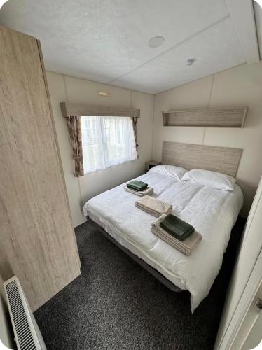 a bedroom with a bed with two trays on it at Brand New Caravan in Selsey