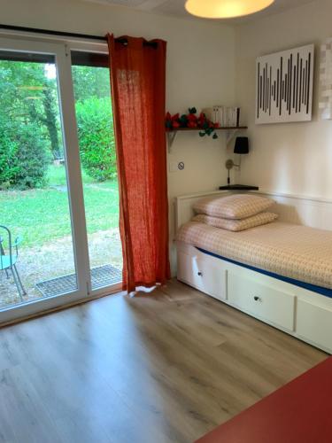 a bedroom with a bed and a sliding glass door at Studio Tennis Riviere in Annecy