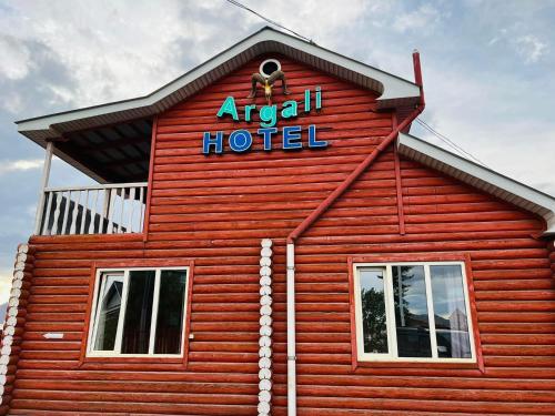 ein rotes Gebäude mit einem Hotelschild darauf in der Unterkunft Argali hotel in Bügat