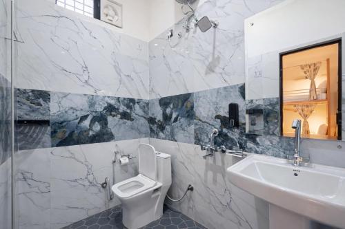 a bathroom with a white toilet and a sink at Live Free Hostel Dehradun in Dehradun