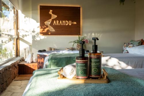 two bottles of shampoo sitting on top of a bed at Hotel Velas do Engenho in Ilhabela