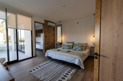 a bedroom with a bed and a glass door at Casa Reserva jacuzzi Climatizado, Diseño y Naturaleza en Chacras de Coria in Ciudad Lujan de Cuyo