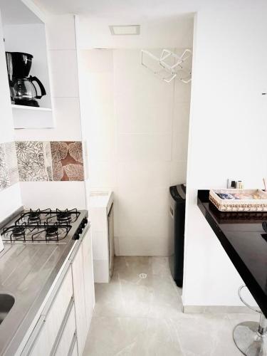 a white kitchen with a stove and a sink at Apartamento central Moderno de lujo y con piscina in Villavicencio