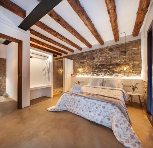a bedroom with a large bed with a stone wall at ruralhomemora in Mora de Rubielos