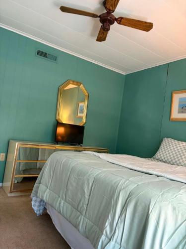 a bedroom with a bed with a ceiling fan and a mirror at Beach Condo in Ocean City, MD in Ocean City