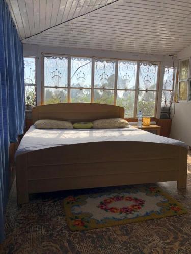 a bedroom with a large bed in front of windows at Burj Hotel Kottli Sattian in Ban