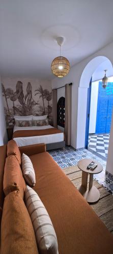 a hotel room with two beds and a table at Dar Mounia Les Oudayas in Rabat