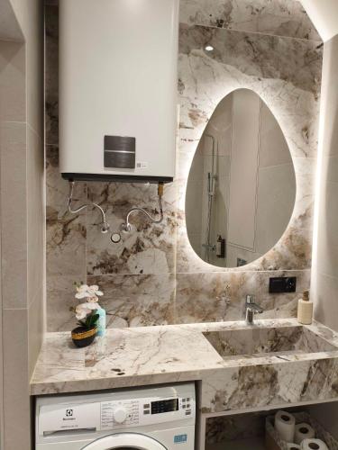 a bathroom with a sink and a mirror at Apartament Krótka in Łomża