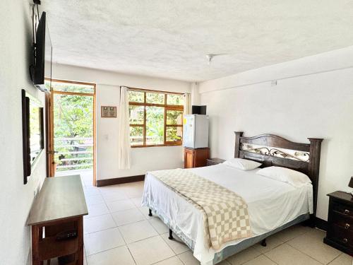 a bedroom with a bed and a large window at Hotel Xetawaa´l in San Pedro La Laguna