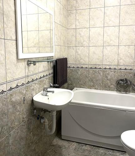 a bathroom with a sink and a tub and a toilet at Apartman LUXE STAY Vujović in Bileća