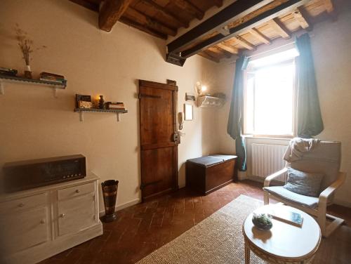 a living room with a chair and a table and a window at Il sogno di Tania in Pescia
