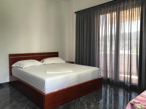 a bedroom with a bed and a large window at Glaunkel in Ksamil