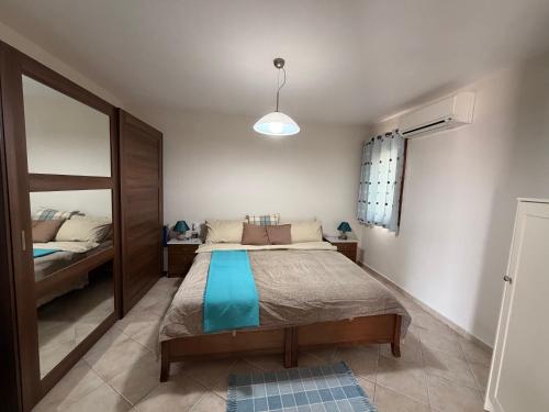 a bedroom with a bed and a mirror at Cozy Aegean Escape in Skopelos Town