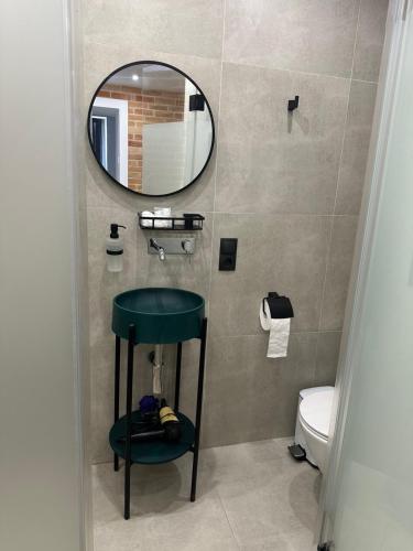 a bathroom with a green stool and a mirror at Historical Apartments by Stepan Fedak in Lviv