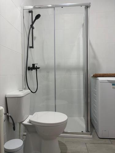 a white bathroom with a toilet and a shower at Paraíso del Encanto in Adeje