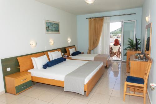 a bedroom with two beds and a balcony at Sunrise Beach Hotel in Ammoudia