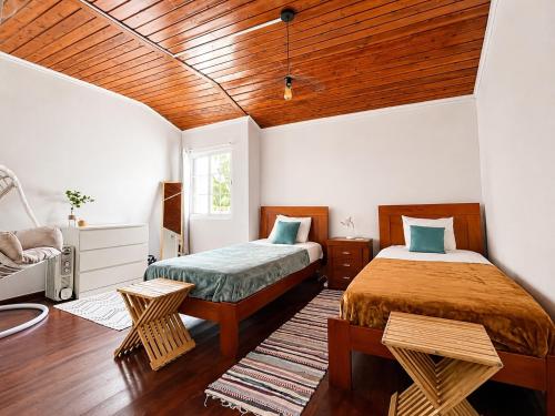 a bedroom with two beds and a wooden ceiling at Botânico Guesthouse in Nordeste
