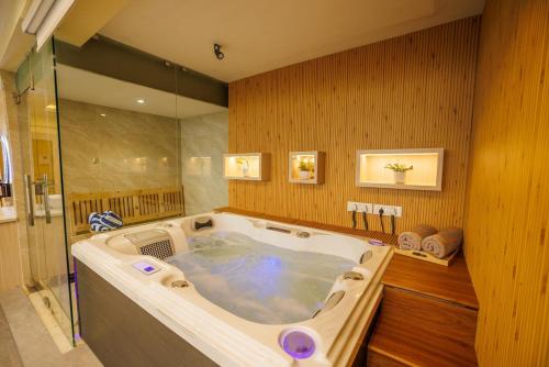 a jacuzzi tub in a room with wooden walls at Himalayan Heights Penthouse in Pātan