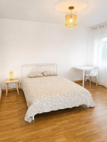 a white bedroom with a bed and a table at Independent 2-room apartment in Senhora da Hora