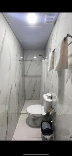 a white bathroom with a toilet and a shower at Rest hotel in Samarkand