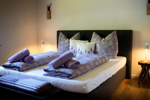 a bed with pillows and blankets on top of it at Anna's Landhaus in Soltau