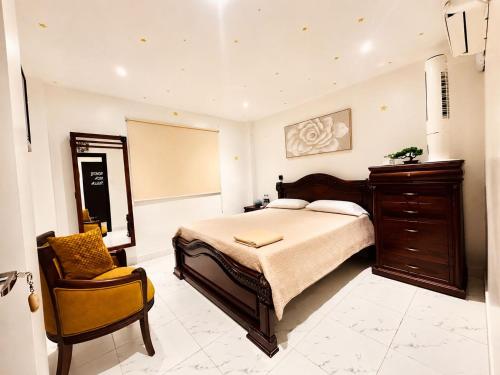 a bedroom with a large bed and a chair at Sweet Home in San Guillermo
