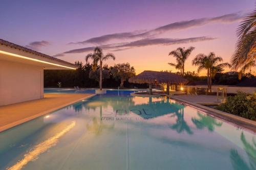 an infinity pool in a villa at sunset at Spot Troia - Boutique Suites in Troia