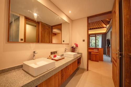 a bathroom with two sinks and a mirror at Apittoya Villas in Gianyar