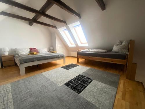 a bedroom with two beds and a rug at FeWo 02 Maisonette im Carre`Charlott in Pulsnitz
